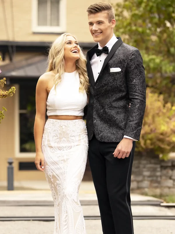 Man in a granite paisley jacket with a woman in a white shirt and shirt long skirt