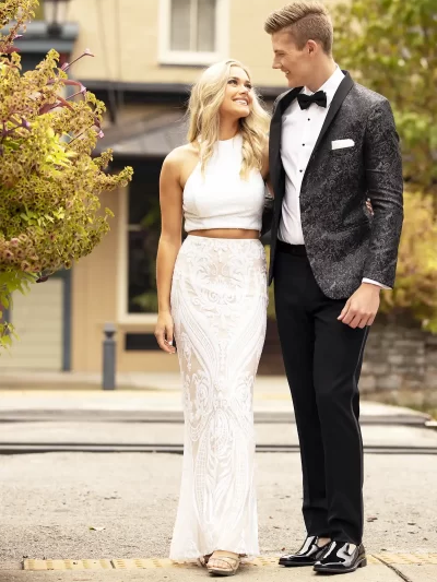 Man in a granite paisley jacket with a woman in a white shirt and shirt long skirt