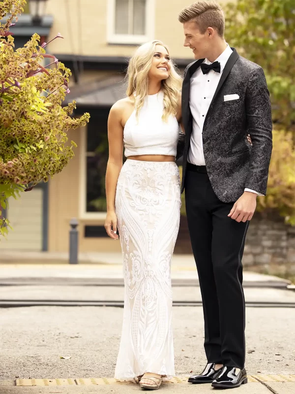 Man in a granite paisley jacket with a woman in a white shirt and shirt long skirt
