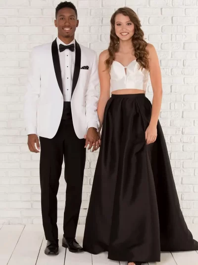 Man in a Clayton white jacket with black trim and a woman in a white top with a black long skirt