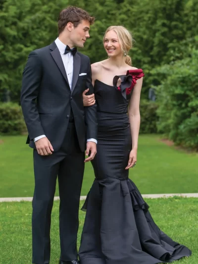 Man in a black J Sebastian tuxedo with a black bow tie and a woman in a black dress