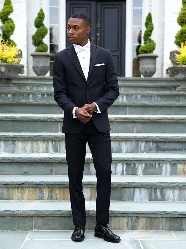 Man in a black J Sebastian tuxedo with a vest and white bow tie
